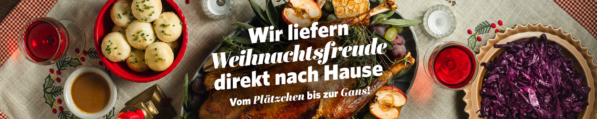 Ein festlich gedeckter Tisch mit klassischem Weihnachtsessen: In der Mitte ein Truthahn, daneben Rotkohl und Klöße als Beilage.