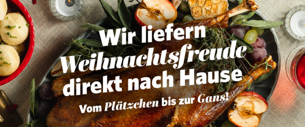 Ein festlich gedeckter Tisch mit klassischem Weihnachtsessen: In der Mitte ein Truthahn, daneben Rotkohl und Klöße als Beilage.