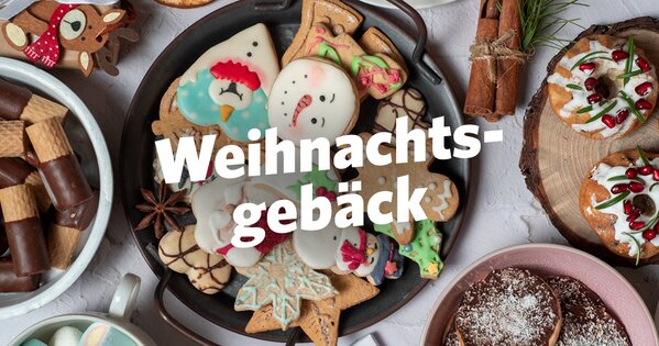 Viele Kekse, zwei Donuts, Zimt und Weihnachtsdeko liegen zusammen. Einige Kekse sind liebevoll verziert und festlich gestaltet.