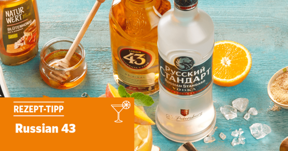 Blauer Tisch mit Honig, Likör 43, Russian Standart Vodka, Eis und einer halben Orange
