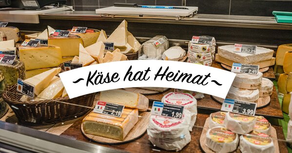 Frischetheke mit einer vielfältigen Auswahl an Käse aus verschiedenen Regionen, appetitlich angerichtet und mit Preisschildern versehen.