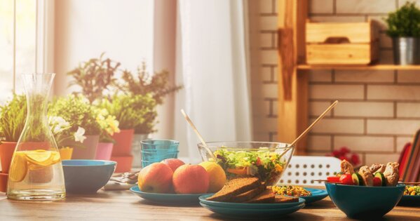 Gedeckter Tisch mit Salat, Obst und Brot