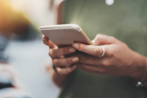Person die ein Handy in der Hand hält