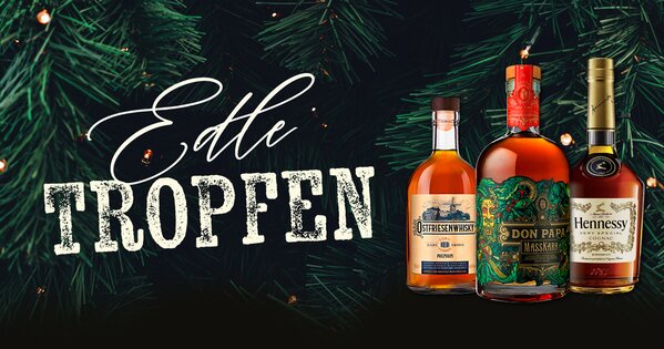 Drei Flaschen hochwertiger Spirituosen vor Tannenzweigen mit Schriftzug „Edle Tropfen“ und Button „Hier entdecken