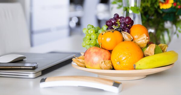 Handy, Laptop, Obstschale mit Trauben, Bananen, Aepfeln udn Orangen